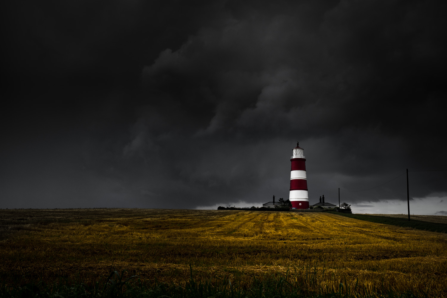 Happisburgh lighthouse with dark approaching bad weather.